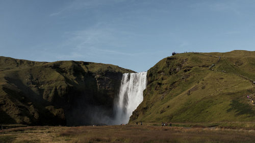 Scenic view of waterfall against sky