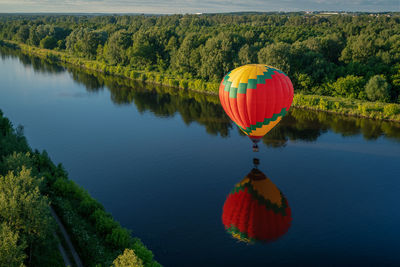 Hot air balloon flying over lake