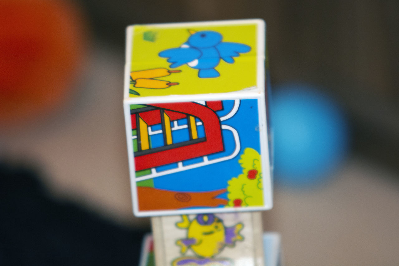 CLOSE-UP OF YELLOW TOYS ON BLUE WALL