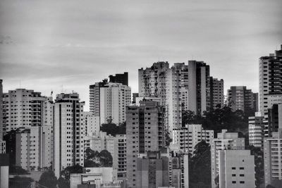 Skyscrapers in city against cloudy sky