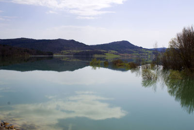 Scenic view of lake and mountains against sky