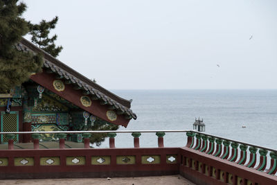 Built structure by sea against sky