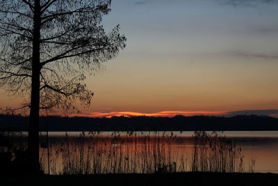Scenic view of lake against sky at sunset