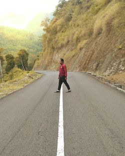 Rear view of man cycling on road