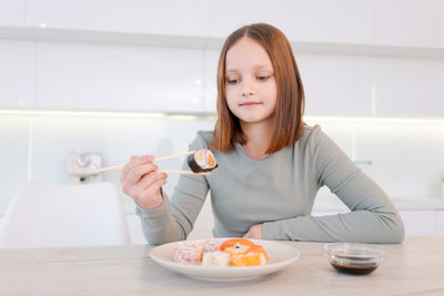 Portrait of young woman using mobile phone at home