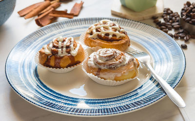 Cinnamon rolls, freshly baked on a plate kitchen tabletop - baking and home cooking concept image.