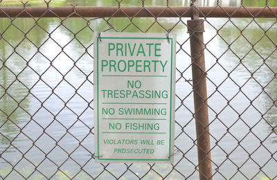 Warning sign on chainlink fence