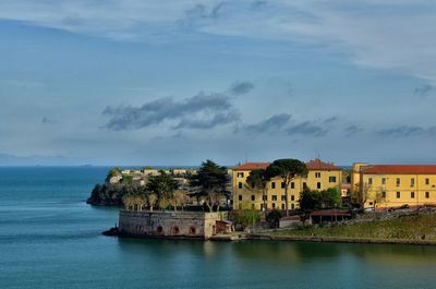 Town by sea against sky