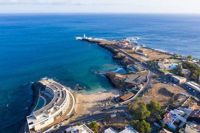 High angle view of city by sea against sky