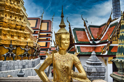 Low angle view of statues on building against sky