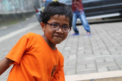 Portrait of boy wearing sunglasses on footpath