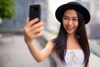 Portrait of smiling young woman using mobile phone