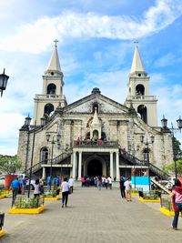 People at cathedral against sky