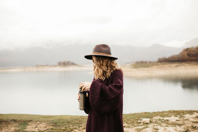 Rear view of woman standing against sky