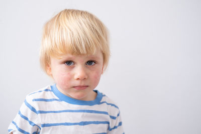 Close-up of cute boy against white background