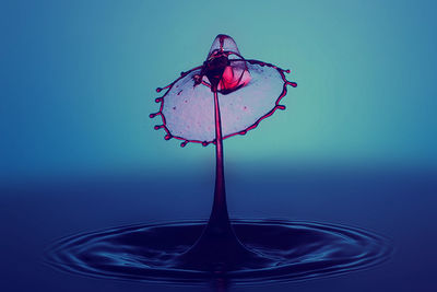 Close-up of drop splashing on blue water