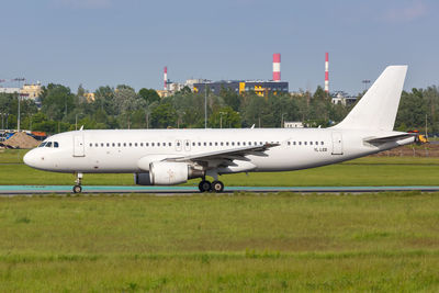 Airplane on airport runway against sky