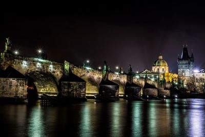 Low angle view of illuminated bridge and church at night
