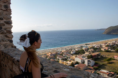 Side view of model looking at sea against sky