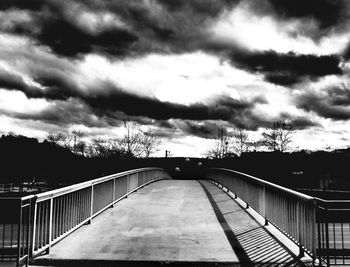 Bridge against cloudy sky