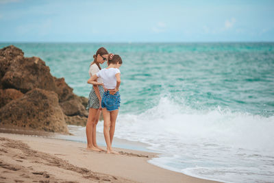 Rear view of woman standing at beach