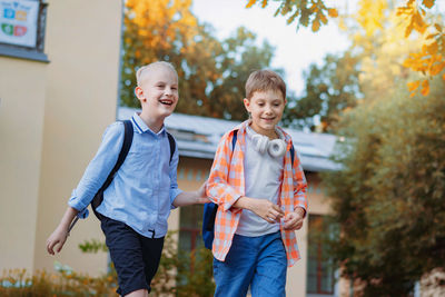 Cheerful excited boys go from school