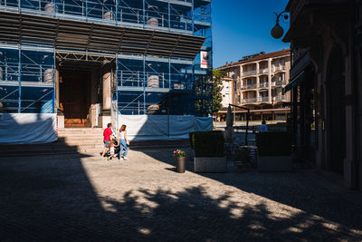 People on street amidst buildings in city