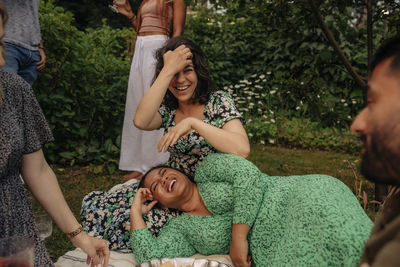 Happy female friends sitting and enjoying at garden party