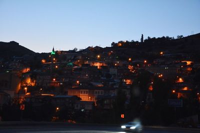 Illuminated cityscape against clear sky at night