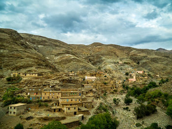 Scenic view of townscape and mountains against sky