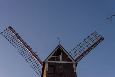 Low angle view of crane against clear sky