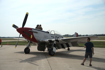 Man on airport runway against sky