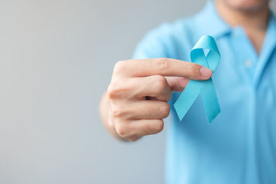 Close-up of person holding hands over white background