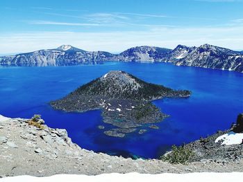 Scenic view of lake and snowcapped mountains against sky