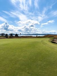 Scenic view of golf course against sky