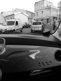 Cars on road by buildings in city