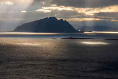 Rocky coastline with sunbeams at dusk