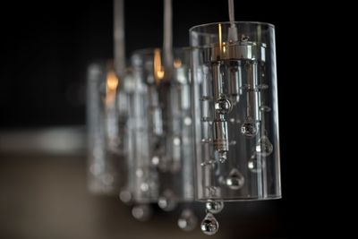 Close-up of pendant lights hanging against black background