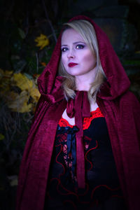 Beautiful woman in little red riding hood costume at forest