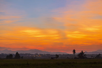 Scenic view of field against orange sky