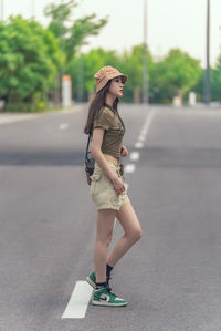 Young woman standing on road