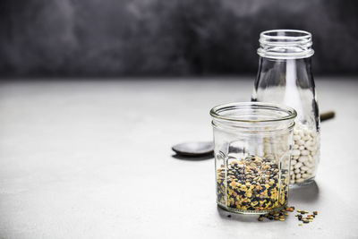 Close-up of food in jar on table against wall