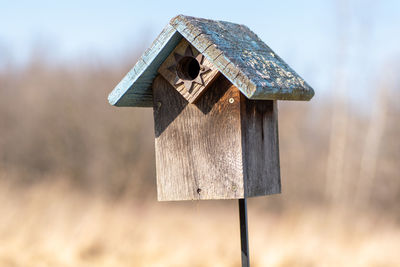 Low angle view of birdhouse on field