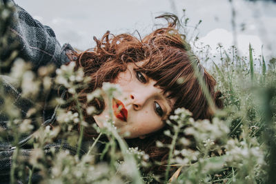 Portrait of young woman lying on plants