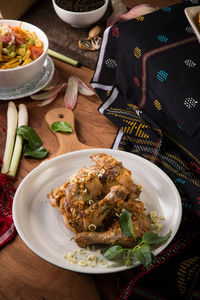 Grilled chicken served on plate on table