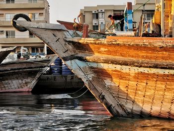 Nautical vessel on sea against buildings