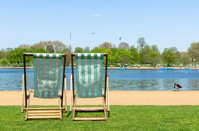 Deck chairs  in a london park against clear sky in summer