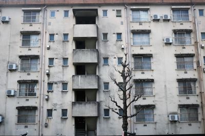 Low angle view of aging concrete building in city