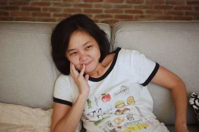 Portrait of teenage girl sitting on sofa at home