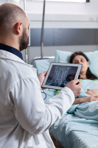 Male doctor looking at x-ray on digital tablet